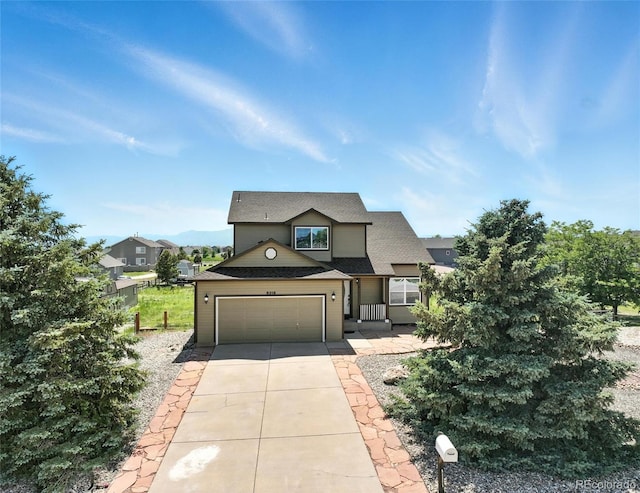 traditional-style home with driveway, an attached garage, and a shingled roof