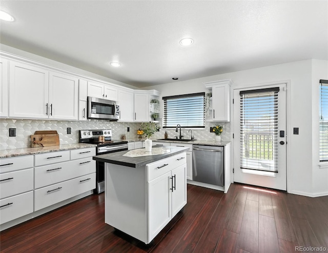 kitchen with stainless steel appliances, white cabinetry, backsplash, dark wood-style floors, and recessed lighting
