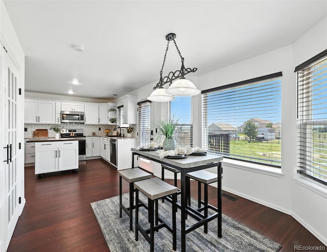 dining space featuring healthy amount of natural light and dark wood finished floors