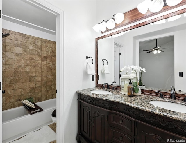 full bath with double vanity, ceiling fan, and shower / bathtub combination