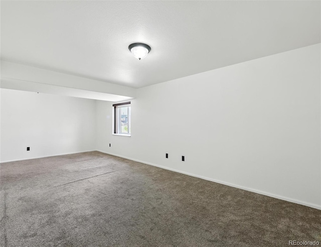 spare room featuring carpet flooring and baseboards