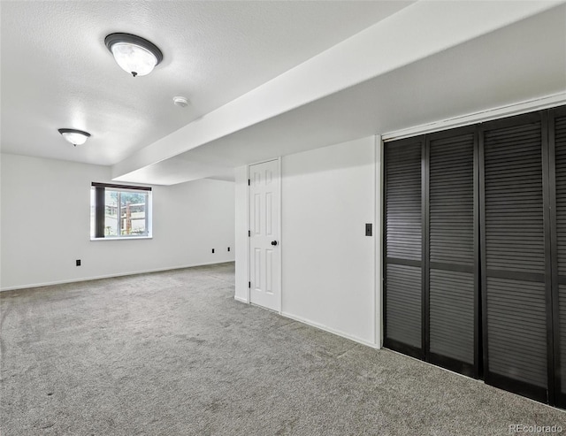 below grade area with carpet flooring and a textured ceiling