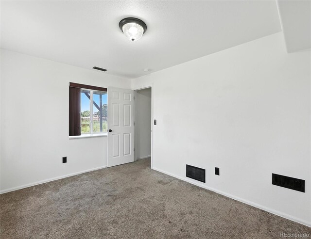 carpeted empty room with baseboards