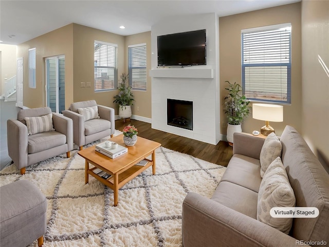 living room with a fireplace and dark wood-type flooring