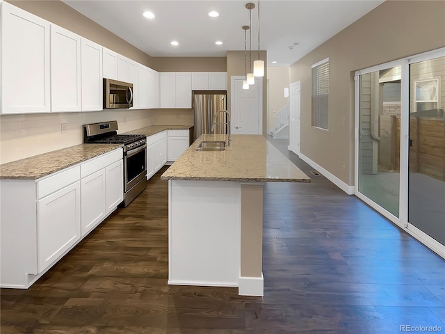 kitchen featuring white cabinetry, a kitchen island with sink, hanging light fixtures, and appliances with stainless steel finishes