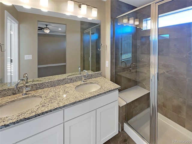 bathroom with ceiling fan, a shower with door, and vanity