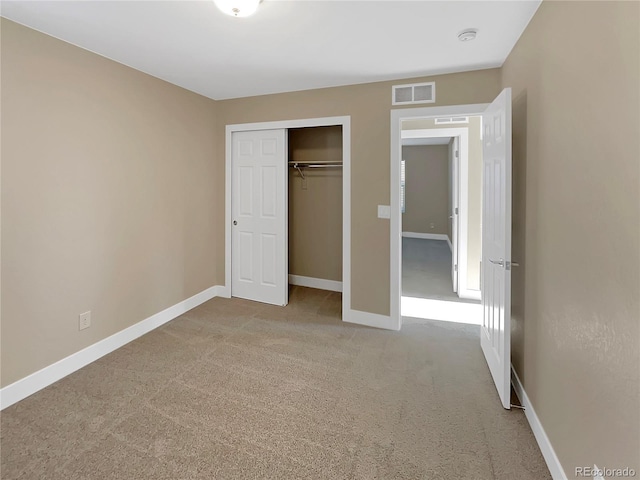 unfurnished bedroom featuring light colored carpet and a closet