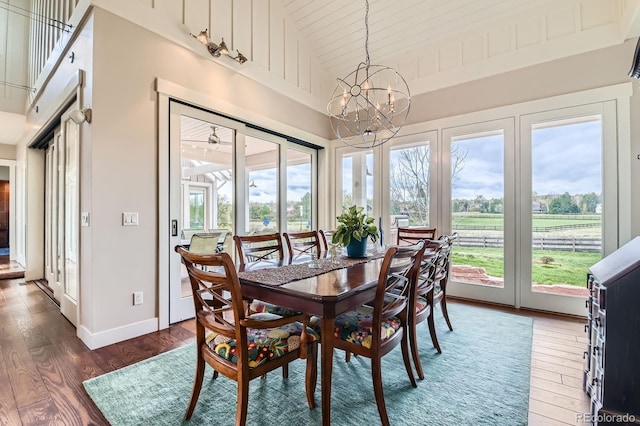 dining area featuring high vaulted ceiling, a chandelier, wood ceiling, and wood finished floors