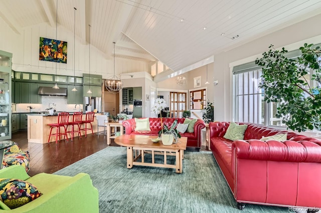 living area featuring high vaulted ceiling, an inviting chandelier, beam ceiling, and dark wood-type flooring
