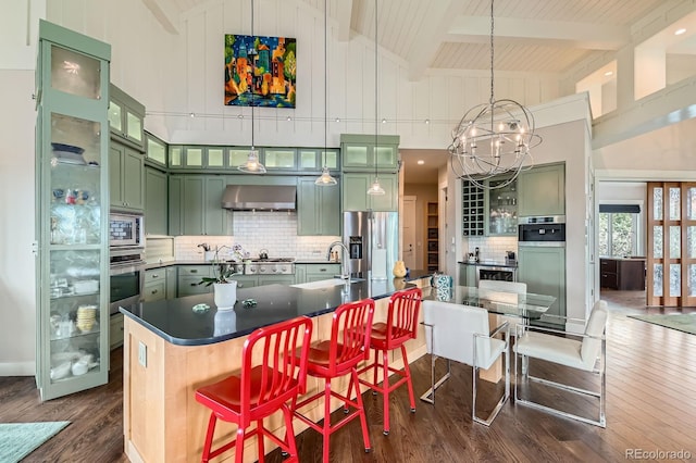 kitchen with wall chimney range hood, dark wood-style flooring, appliances with stainless steel finishes, high vaulted ceiling, and green cabinets
