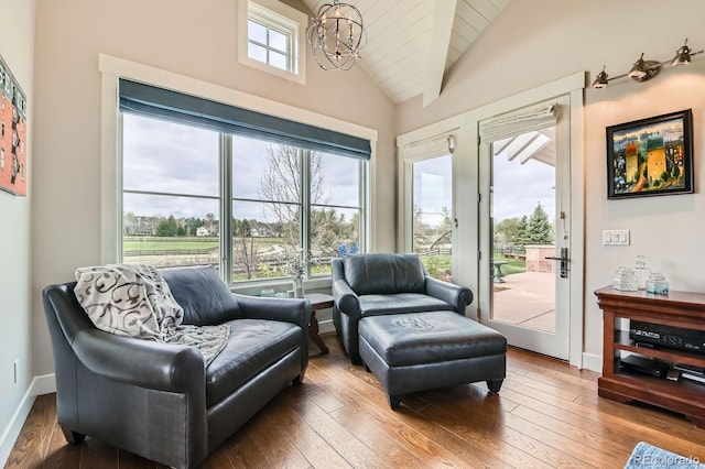 living area featuring beam ceiling, baseboards, high vaulted ceiling, hardwood / wood-style flooring, and a notable chandelier