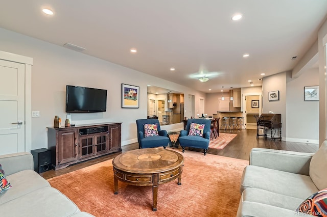 living area with visible vents, recessed lighting, baseboards, and wood finished floors