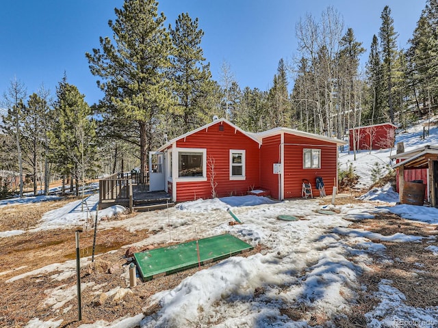 snow covered rear of property featuring a deck