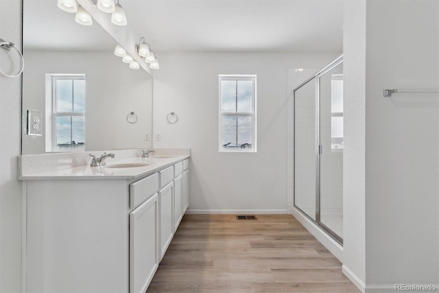 bathroom with vanity, a shower with door, and hardwood / wood-style floors