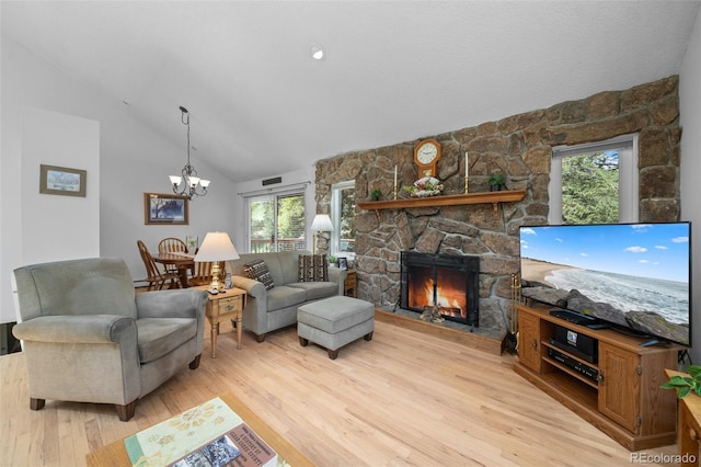649 Cottonwood Dr, Evergreen, CO 80439 - living area with vaulted ceiling, light wood-type flooring, a stone fireplace, plenty of natural light, and a chandelier