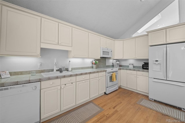 649 Cottonwood Dr, Evergreen, CO 80439 - kitchen featuring white appliances, lofted ceiling, light wood finished floors, and light countertops
