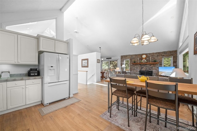 649 Cottonwood Dr, Evergreen, CO 80439 - kitchen with white refrigerator with ice dispenser, high vaulted ceiling, light wood-style flooring, healthy amount of natural light, and a chandelier