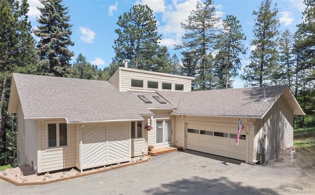 649 Cottonwood Dr, Evergreen, CO 80439 - mid-century home featuring an attached garage, a shingled roof, and asphalt driveway
