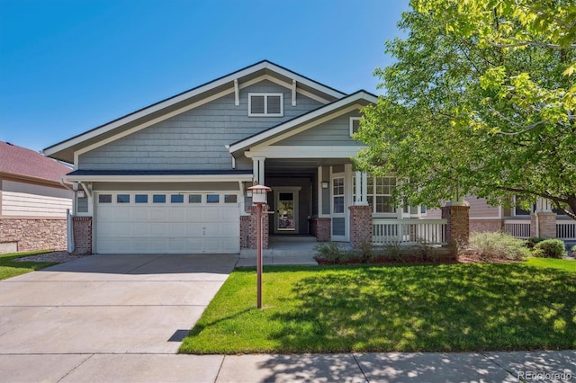 craftsman-style house with brick siding, a garage, a porch, a front lawn, and driveway