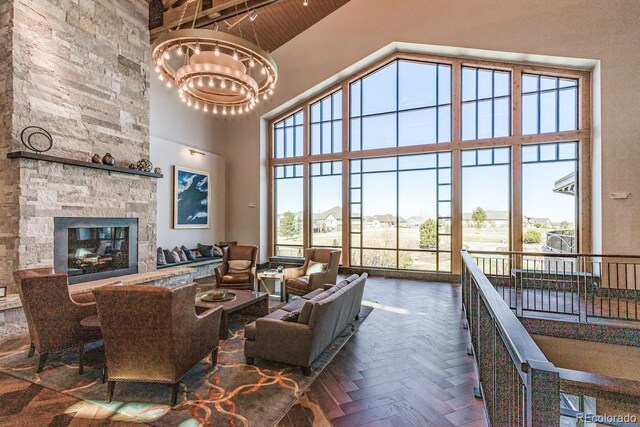 7852 S Addison Way, Aurora, CO 80016 - living room featuring high vaulted ceiling, a chandelier, wood ceiling, and a fireplace