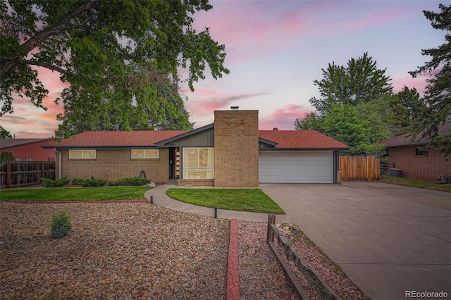 7491 W 45th Ave, Wheat Ridge, CO 80033 - mid-century inspired home with concrete driveway, a chimney, and brick siding