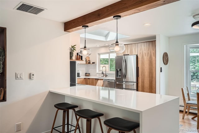 7491 W 45th Ave, Wheat Ridge, CO 80033 - kitchen featuring stainless steel appliances, modern cabinets, a sink, a breakfast bar area, and plenty of natural light