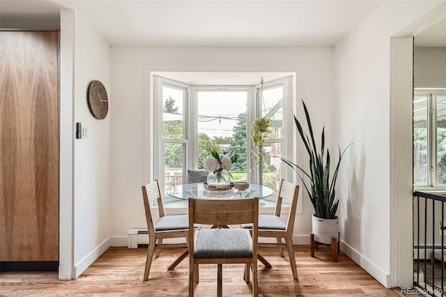 7491 W 45th Ave, Wheat Ridge, CO 80033 - dining room featuring light wood-type flooring, baseboards, a baseboard heating unit, and a baseboard radiator
