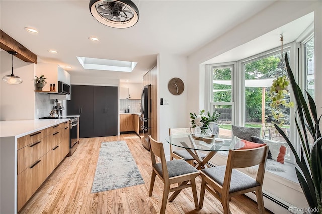 7491 W 45th Ave, Wheat Ridge, CO 80033 - dining area featuring a skylight, light wood-style flooring, recessed lighting, and a baseboard radiator