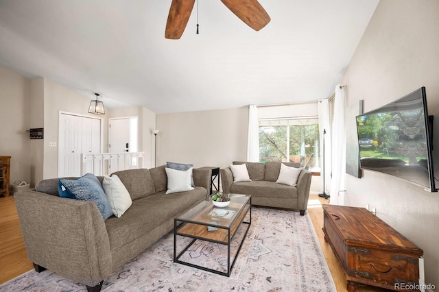 living room with lofted ceiling, light wood finished floors, and ceiling fan