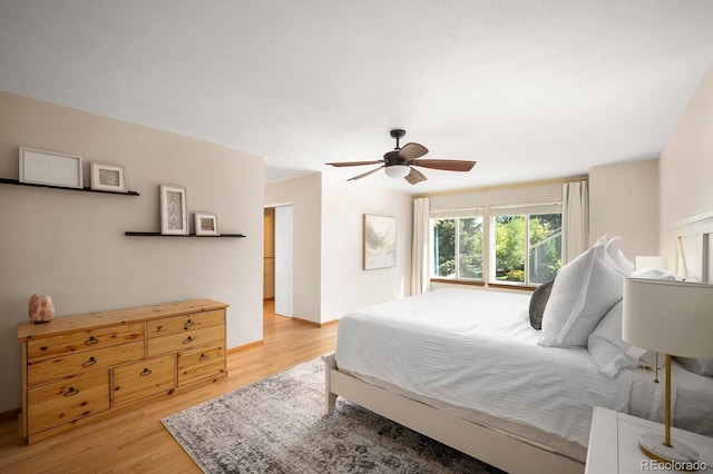 bedroom featuring ceiling fan, light wood finished floors, and baseboards