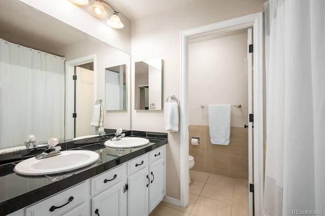 full bath featuring double vanity, tile patterned flooring, a sink, and tile walls