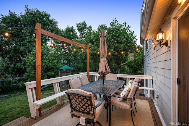 deck at dusk featuring outdoor dining space