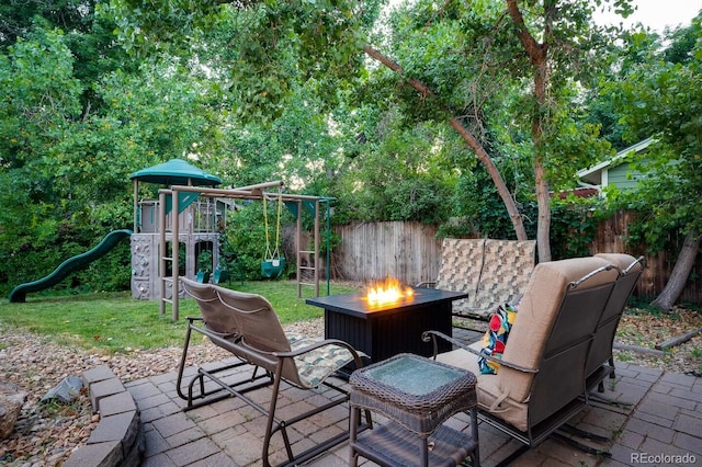 view of patio / terrace with a playground, fence, and a fire pit