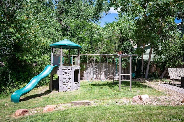 community jungle gym with fence and a yard