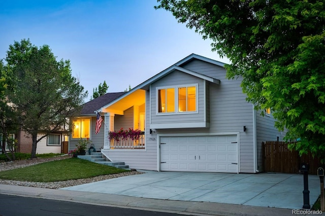 view of front facade featuring a garage, driveway, and fence