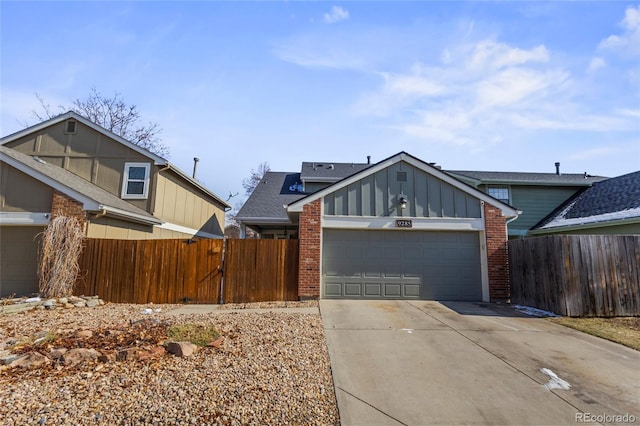 view of front of property with an attached garage, brick siding, fence, driveway, and board and batten siding