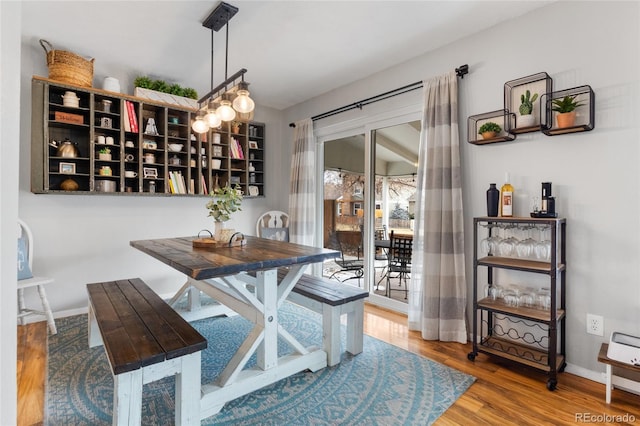 dining space featuring baseboards and wood finished floors