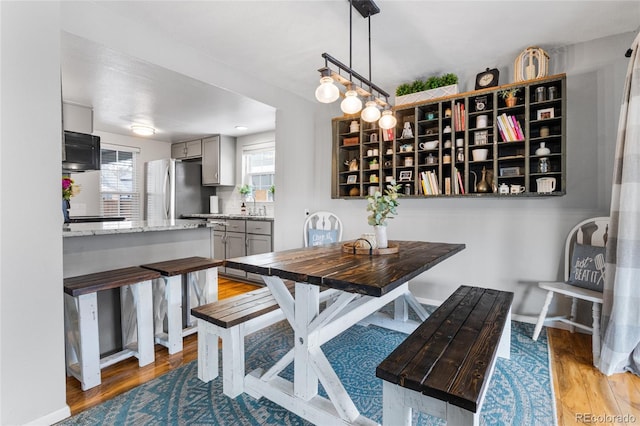 dining area with light wood finished floors and baseboards