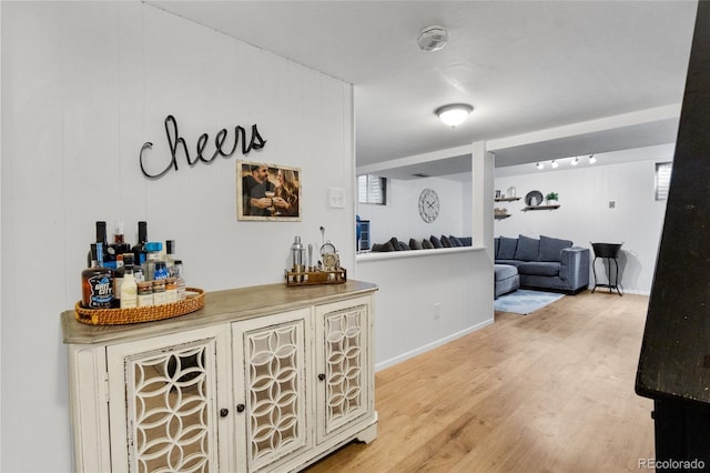 bar featuring a dry bar, baseboards, and wood finished floors