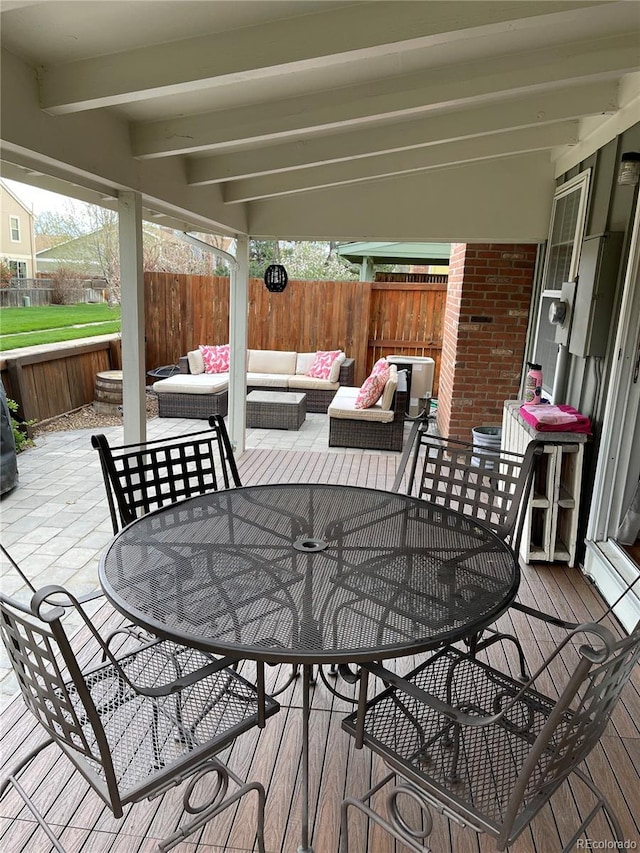 deck featuring outdoor dining space, a patio area, outdoor lounge area, and a fenced backyard