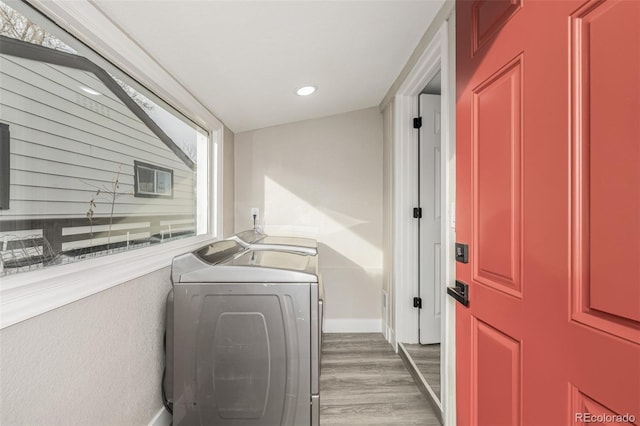 washroom with hardwood / wood-style floors and washing machine and dryer