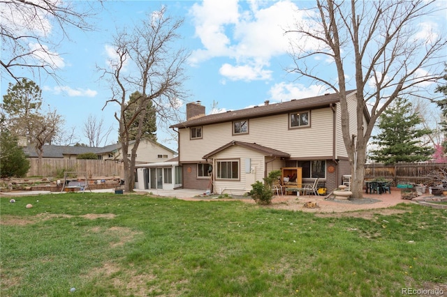 back of property with a patio, a sunroom, a chimney, and brick siding
