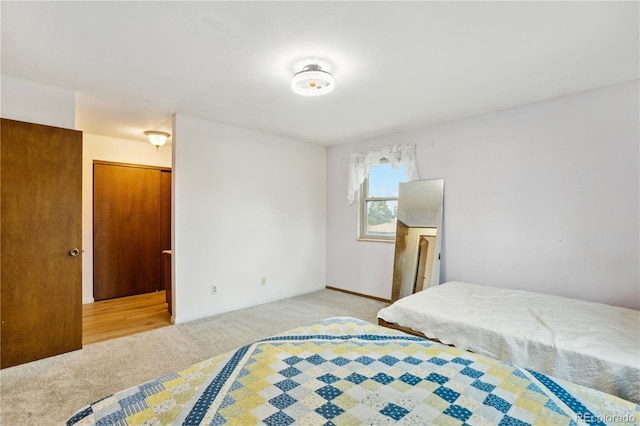 bedroom with light colored carpet and baseboards