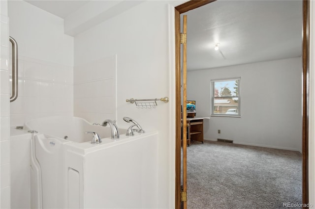 bathroom with a whirlpool tub and baseboards