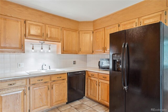 kitchen featuring black appliances, a sink, light countertops, backsplash, and light tile patterned floors