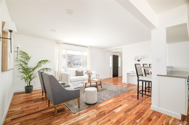 living area featuring baseboards and light wood-style floors