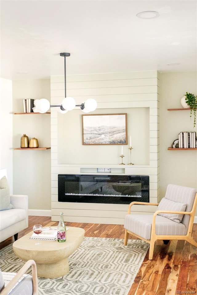 living room with wood finished floors and a glass covered fireplace