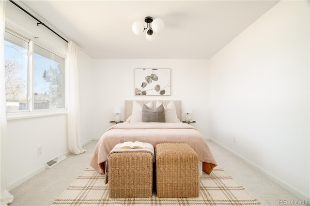 carpeted bedroom with visible vents and baseboards