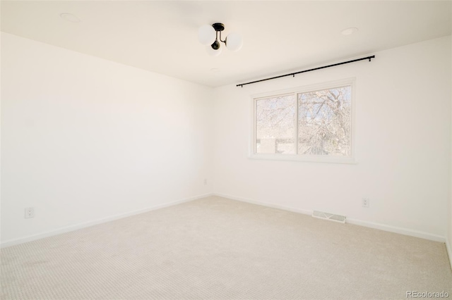 unfurnished room featuring baseboards, visible vents, and light colored carpet