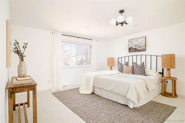 carpeted bedroom with visible vents and an inviting chandelier